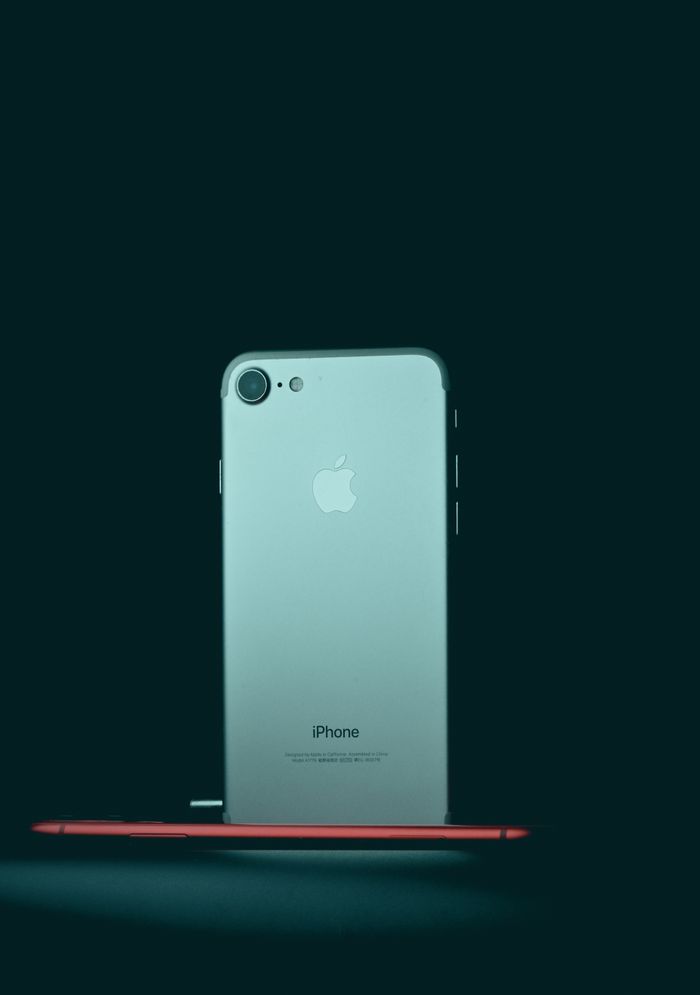 Minimalist shot of iPhone 7 against a dark background, emphasizing sleek design.